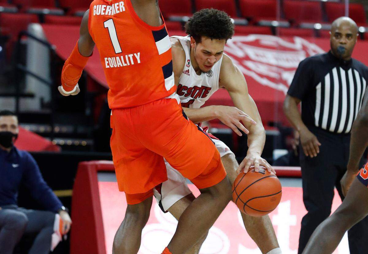 N.C. State’s Jericole Hellems (4) tries to drive around Syracuse’s Quincy Guerrier (1) during the first half of N.C. State’s game against Syracuse at PNC Arena in Raleigh, N.C., Tuesday, February 9, 2021.