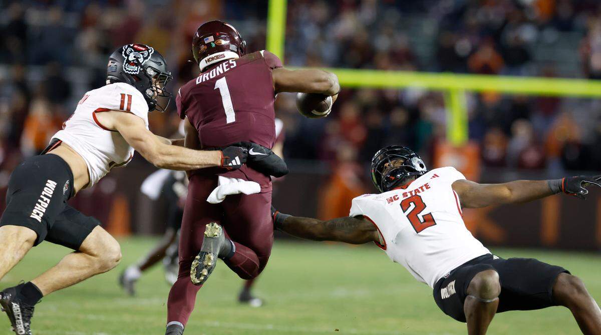 N.C. State linebacker Payton Wilson (11) and Jaylon Scott (2) chase down Virginia Tech quarterback Kyron Drones (1) during the second half of N.C. State’s 35-28 victory over Virginia Tech at Lane Stadium in Blacksburg, VA, Saturday, Nov. 18, 2023.