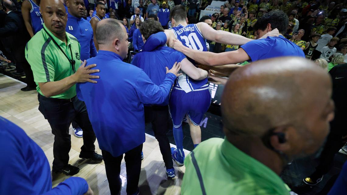 Duke’s Kyle Filipowski (30) is helped off the court after the Wake Forest fans rushed the court after Wake Forest’s 83-79 victory over Duke at Lawrence Joel Veterans Memorial Coliseum in Winston-Salem, N.C., Saturday, Feb. 24, 2024.
