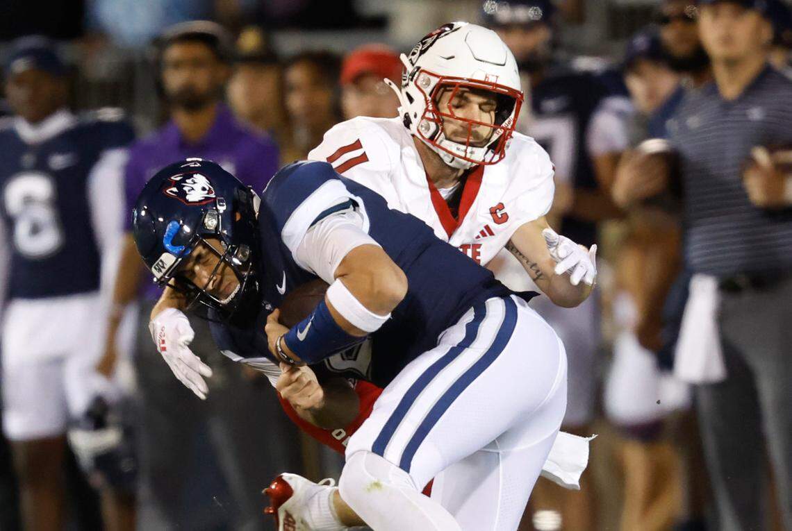 N.C. State linebacker Payton Wilson (11) wraps up Connecticut quarterback Joseph Fagnano (2) during the second half of N.C. State’s 24-14 victory over UConn at Rentschler Field in East Hartford, Conn. Thursday, August 31, 2023.