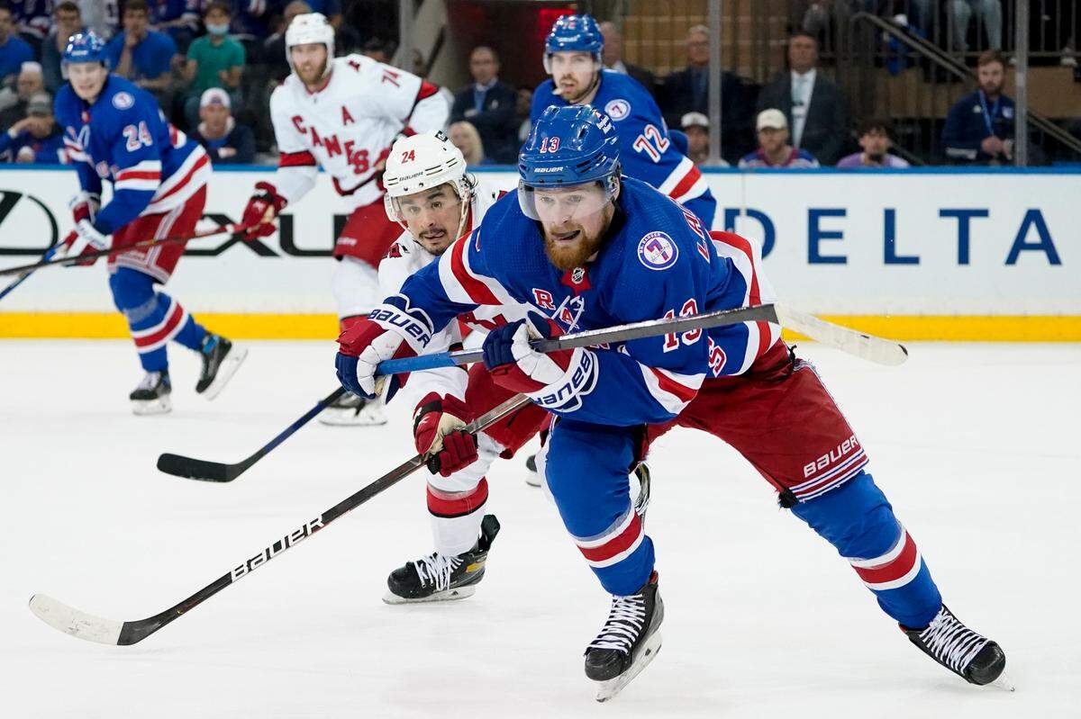 New York Rangers left wing Alexis Lafrenière (13) and Carolina Hurricanes center Seth Jarvis (24) chase the puck with Canes’ Jaccob Slavin (74) behind him during the second period of Game 6 of Stanley Cup second-round playoff series, Saturday, May 28, 2022, in New York. (AP Photo/John Minchillo)