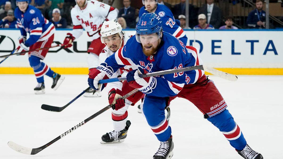 New York Rangers left wing Alexis Lafrenière (13) and Carolina Hurricanes center Seth Jarvis (24) chase the puck with Canes’ Jaccob Slavin (74) behind him during the second period of Game 6 of Stanley Cup second-round playoff series, Saturday, May 28, 2022, in New York. (AP Photo/John Minchillo)