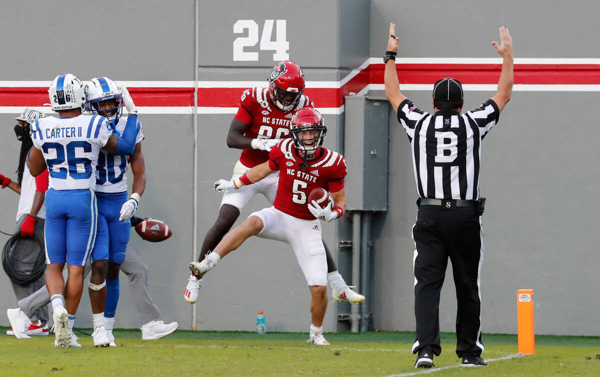 N.C. State’s Thayer Thomas (5) and Emeka Emezie (86) celebrate Thomas’s touchdown during the second half of N.C. State’s 31-20 victory over Duke at Carter-Finley Stadium in Raleigh, N.C., Saturday, Oct. 17, 2020.