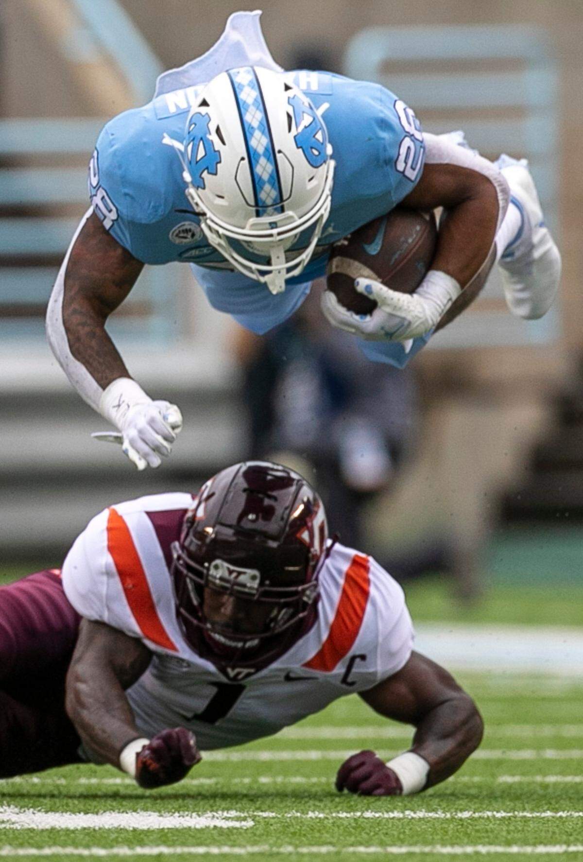 North Carolina’s Omarion Hampton (28) hurdles over Virginia Tech’s Chamarri Conner (1) for a nine yard gain in the first quarter on Saturday, October 1, 2022 at Kenan Stadium in Chapel Hill, N.C.