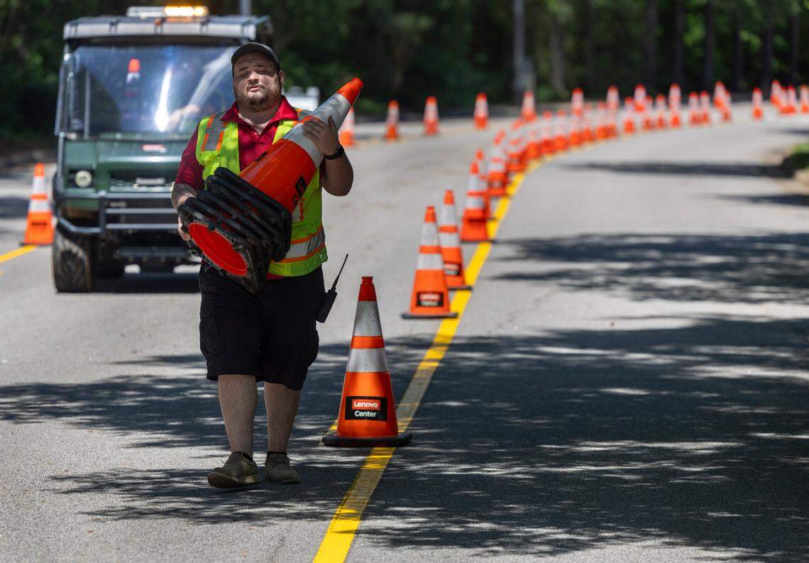 Lenovo Center employee Caleb Glover places traffic cones along Peter Karmanos Jr. Drive on Tuesday, May 6, 2025 at Lenovo Center in Raleigh, N.C.