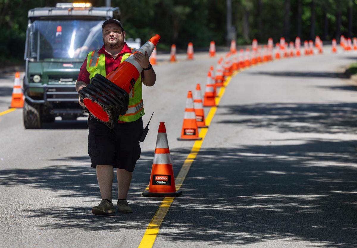 Lenovo Center employee Caleb Glover places traffic cones along Peter Karmanos Jr. Drive in preparation for the Linkin Park concert on Tuesday, May 6, 2025 at Lenovo Center in Raleigh, N.C.