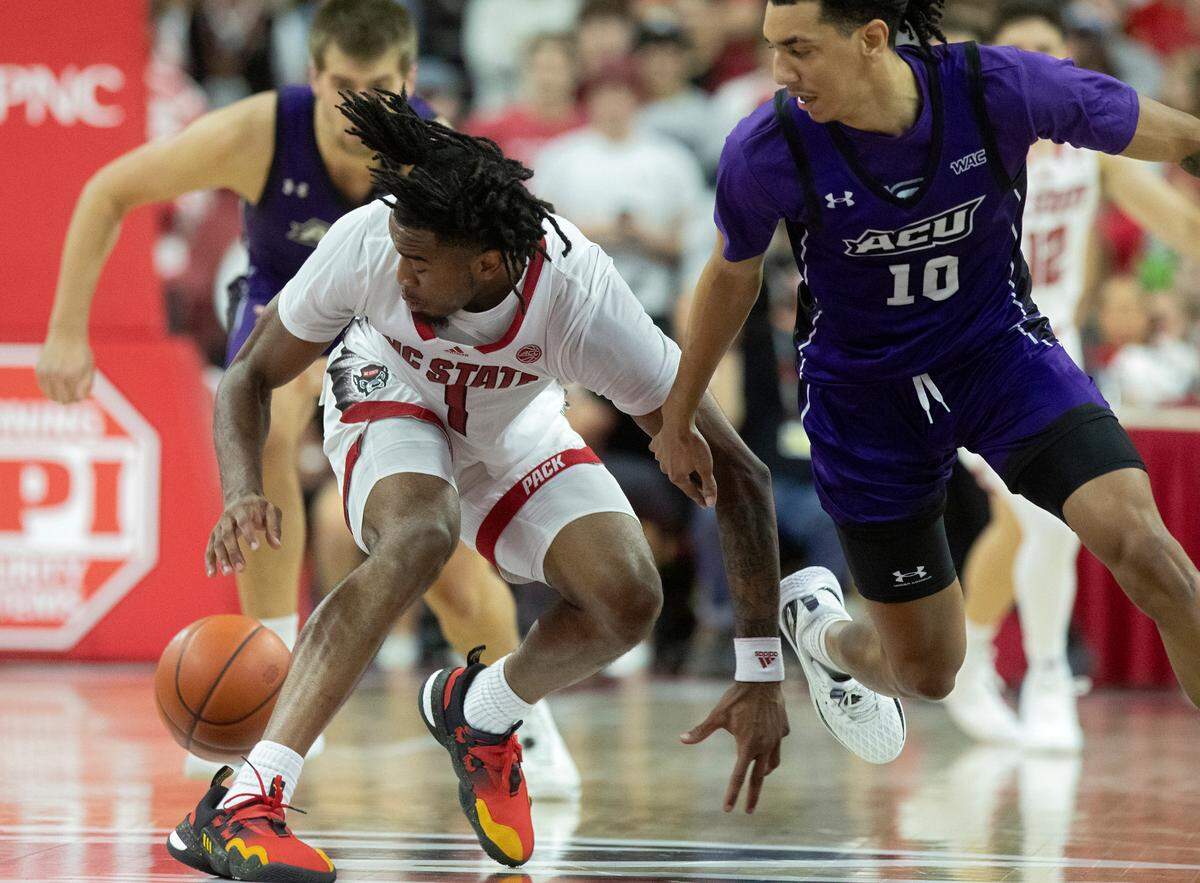 N.C. State’s Jayden Taylor lunges past Abilene Christian’s Nasir DeGruy for a loose ball during the second half of the Wolfpack’s 84-64 win on Friday, Nov. 10, 2023, at PNC Arena in Raleigh, N.C.