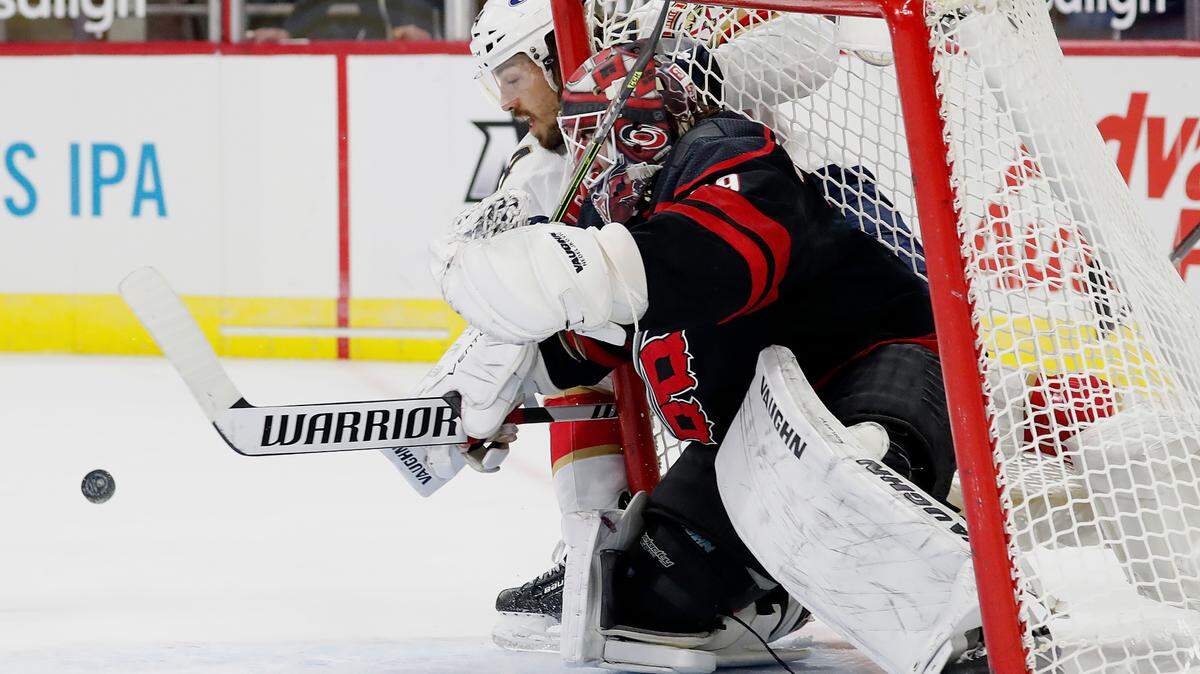 Florida Panthers’ Ryan Lomberg (94) loses the puck as he crashes into the net next to Carolina Hurricanes goaltender Alex Nedeljkovic (39) during the first period of an NHL hockey game in Raleigh, N.C., Wednesday, Feb. 17, 2021. (AP Photo/Karl B DeBlaker)