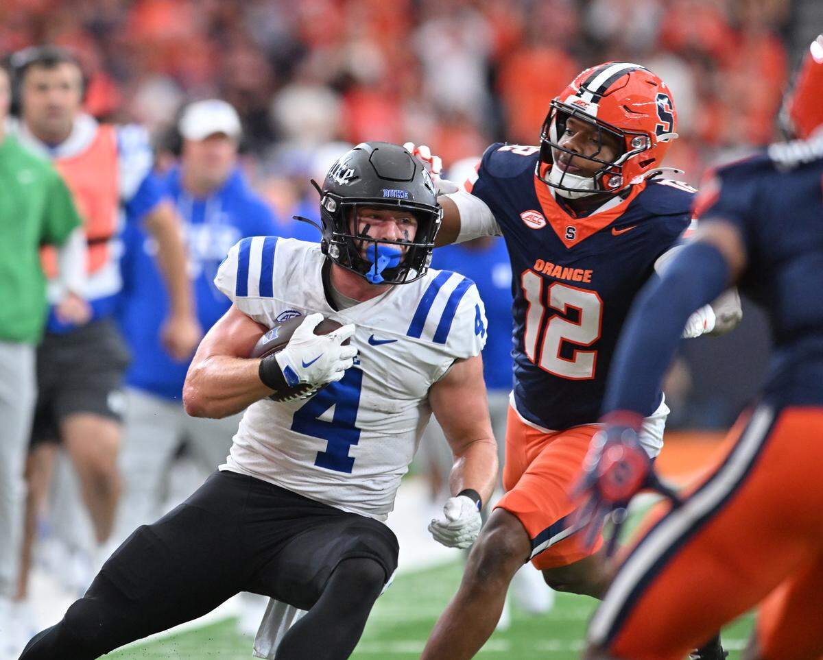 Sep 27, 2025; Syracuse, New York, USA; Duke Blue Devils running back Anderson Castle (4) prepares for contact from Syracuse Orange linebacker Anwar Sparrow (12) in the second quarter at the JMA Wireless Dome. Mandatory Credit: Mark Konezny-Imagn Images