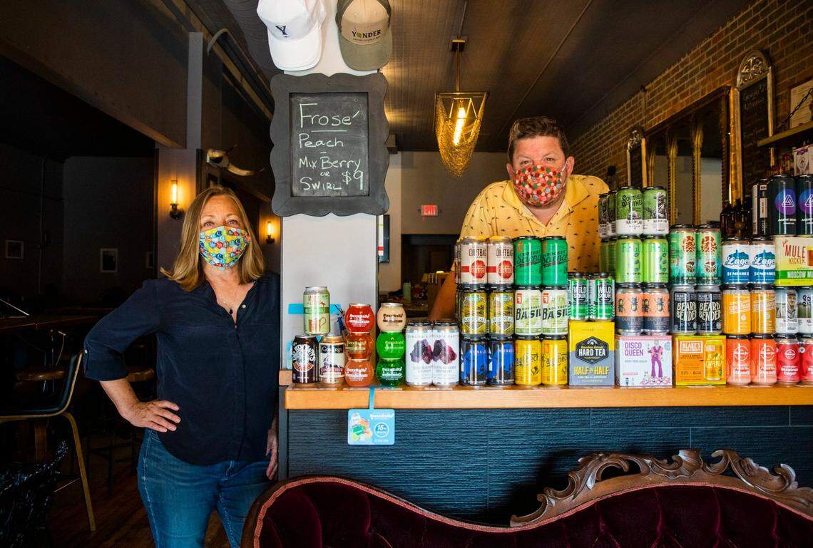 Lana Pierce, left, and Eryk Pruitt stand for a portrait in the small retail area in the front of the bar they own, Yonder Bar, to be able to pay their rent amid Gov. Roy Cooper’s restrictions to prevent the spread of COVID-19, which progressed to Phase 2.5 the day before but still excluding bars from reopening, on Wednesday, Sept. 2, 2020, in Hillsborough, N.C.