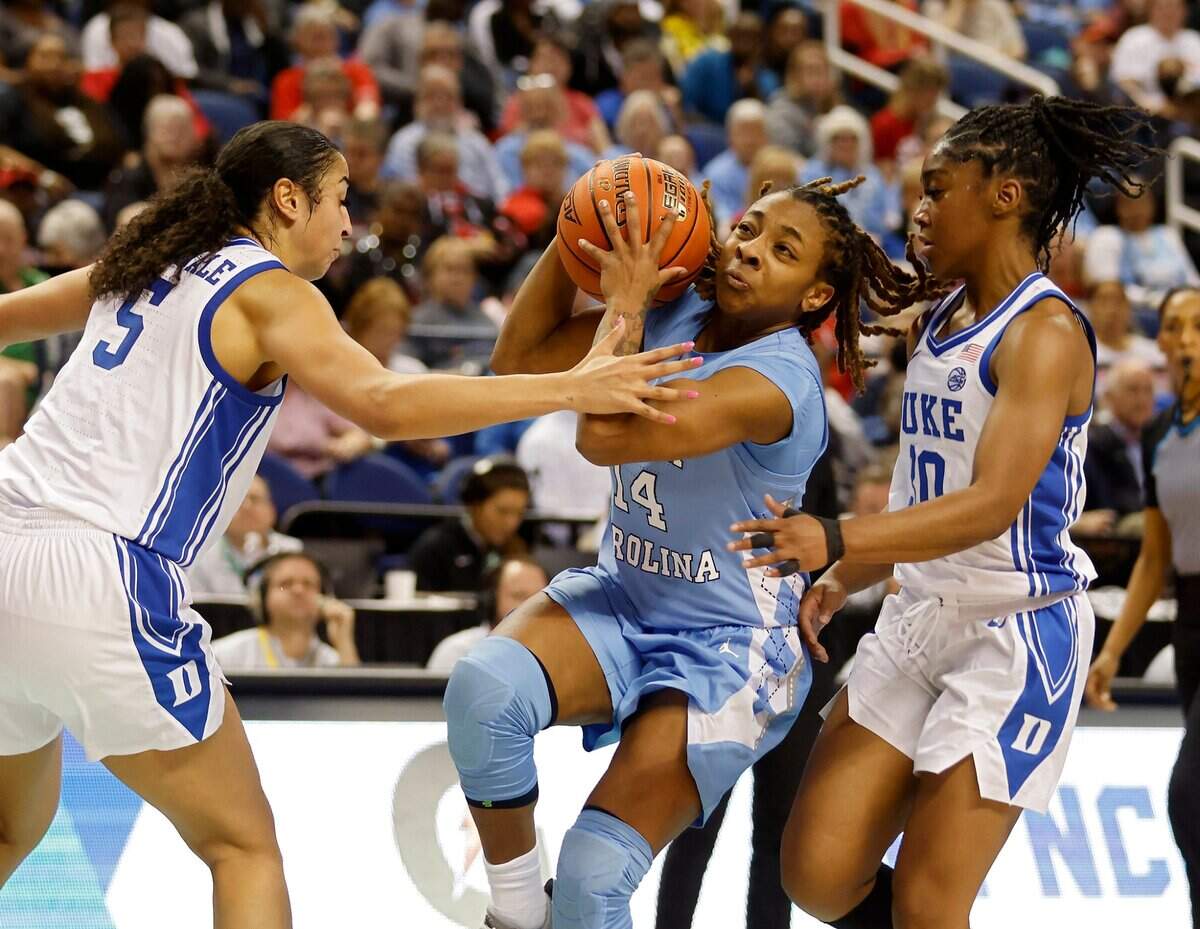 North Carolina’s Kayla McPherson splits the defense of Duke’s Taya Corosdale and Shayeann Day-Wilson to drive to the basket during the first half of an ACC Women’s Basketball Tournament quarterfinal game on Friday, March 3, 2023, at Greensboro Coliseum in Greensboro, N.C.