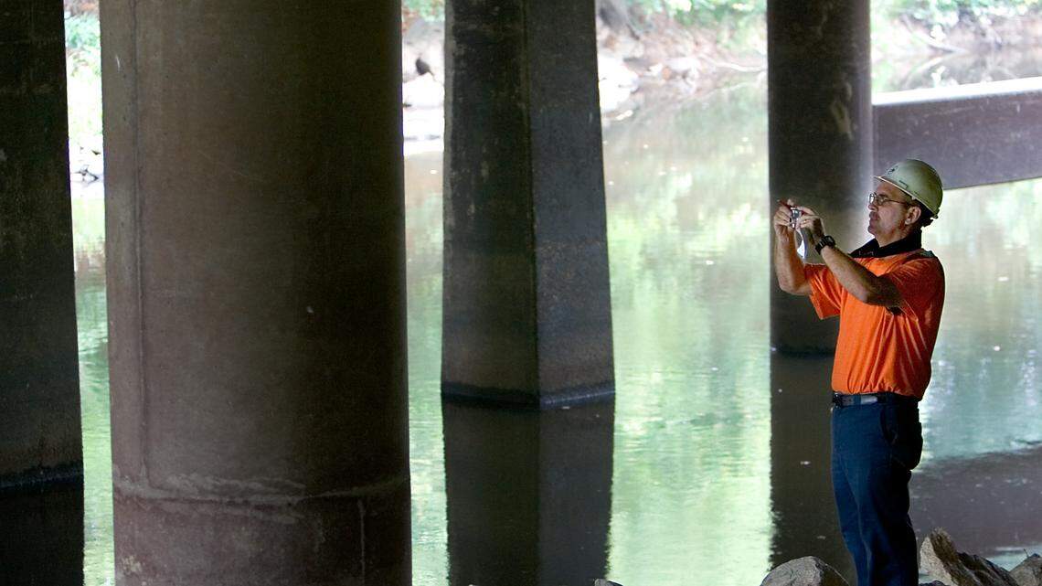 An NCDOT bridge maintenance inspector photographs the Interstate 40/Interstate 85 bridge over the Haw River during an inspection. (AP Photo/News & Record, Joseph Rodriguez)
