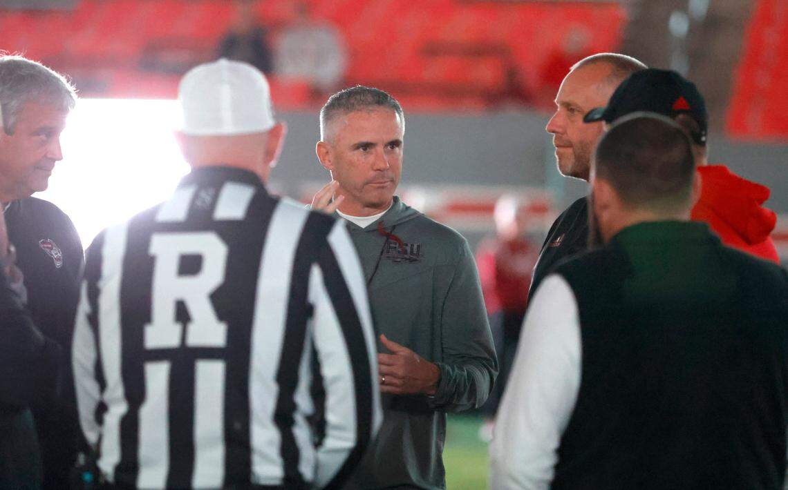 Florida State head coach Mike Norvell talks with N.C. State head coach Dave Doeren with the lights of the stadium out before their game at Carter-Finley Stadium in Raleigh, N.C., Saturday, Oct. 8, 2022.
