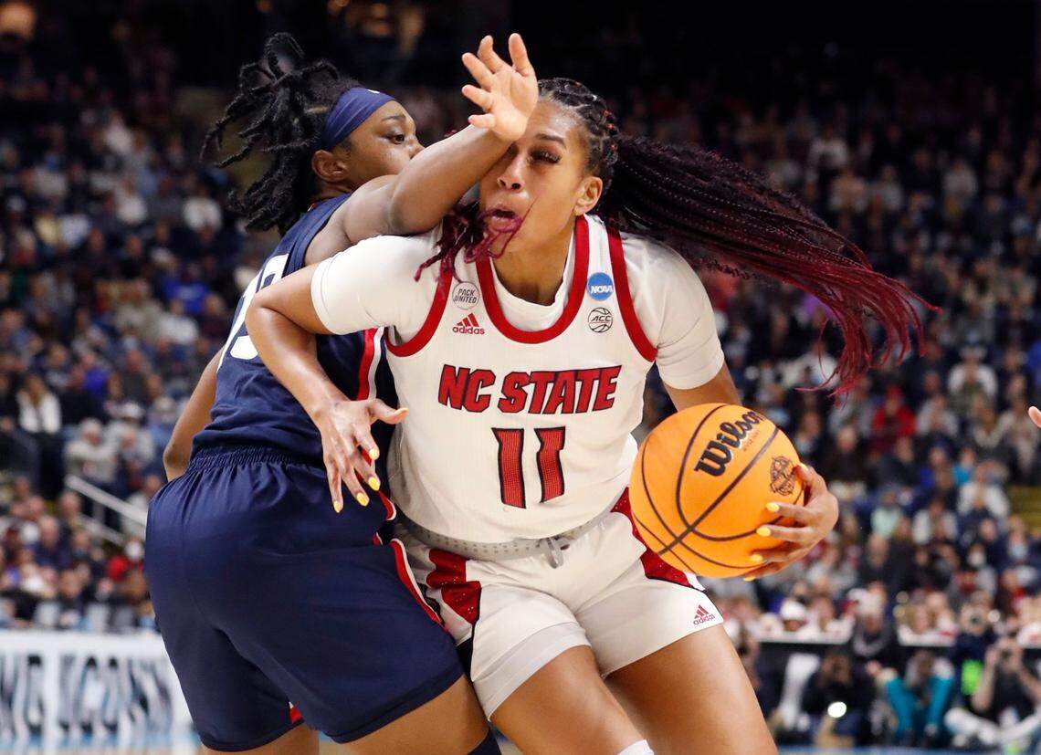 N.C. State’s Jakia Brown-Turner (11) drives around Connecticut’s Christyn Williams (13) during the first half of N.C. States game against the University of Connecticut in the Bridgeport Regional final at Total Mortgage Arena in Bridgeport, Conn., Monday, March 28, 2022.