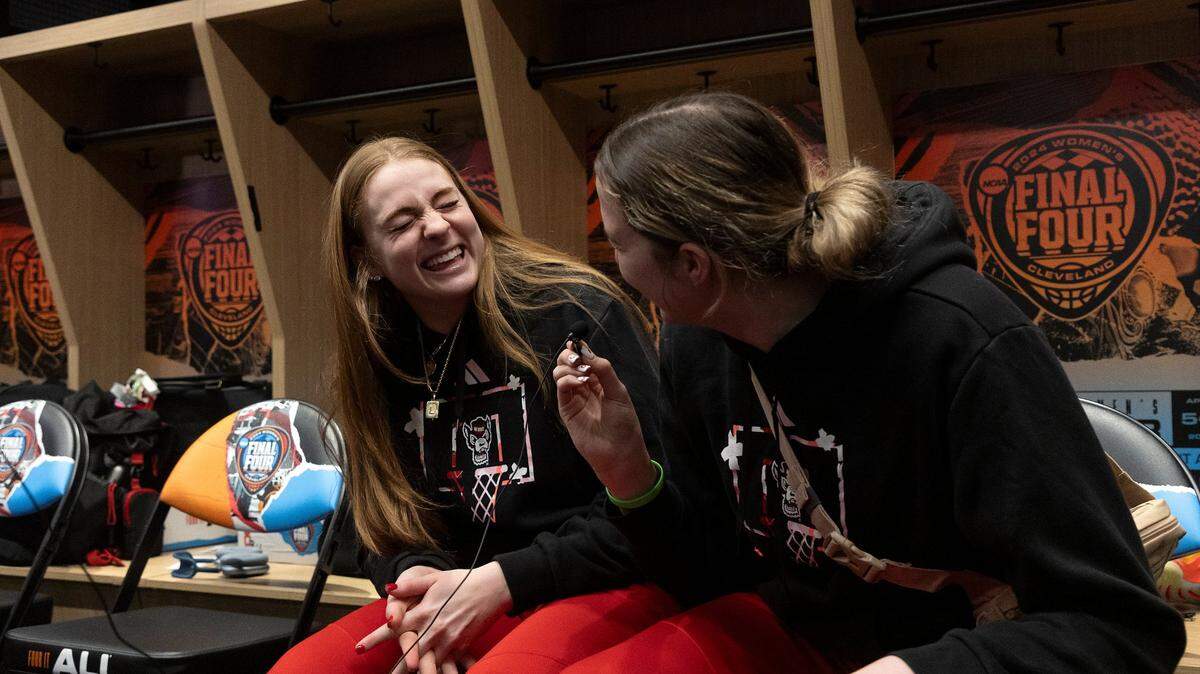N.C. State’s Laci Steele and Lizzy Williamson laugh while answering questions from media in the locker room at Rocket Mortgage FieldHouse on Thursday, April 4, 2024, in Cleveland, Ohio. The Wolfpack will face South Carolina in the Final Four on Friday.