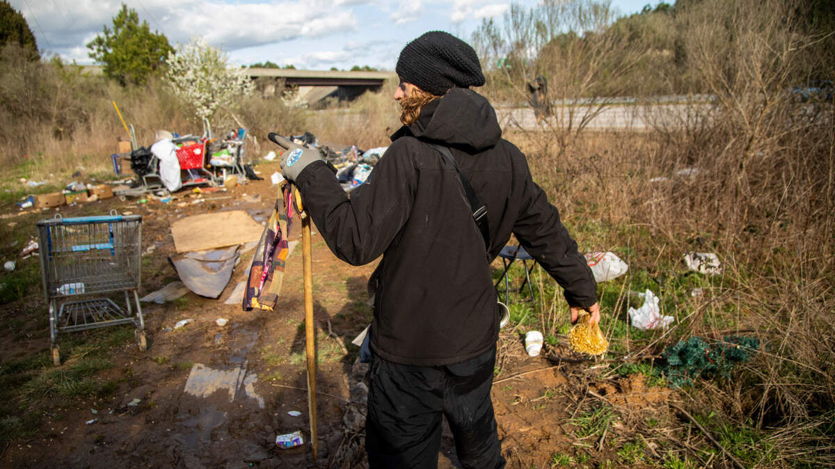 A man at a homeless camp located between Interstate 540 and an exit ramp to Capital Boulevard in 2021.