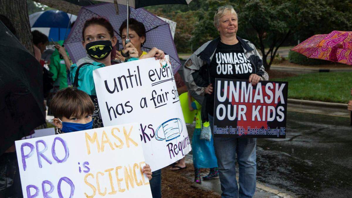 Protesters and counter-protesters demonstrate outside a Wake County Board of Education meeting Tuesday, Aug. 3, 2021 in Cary.