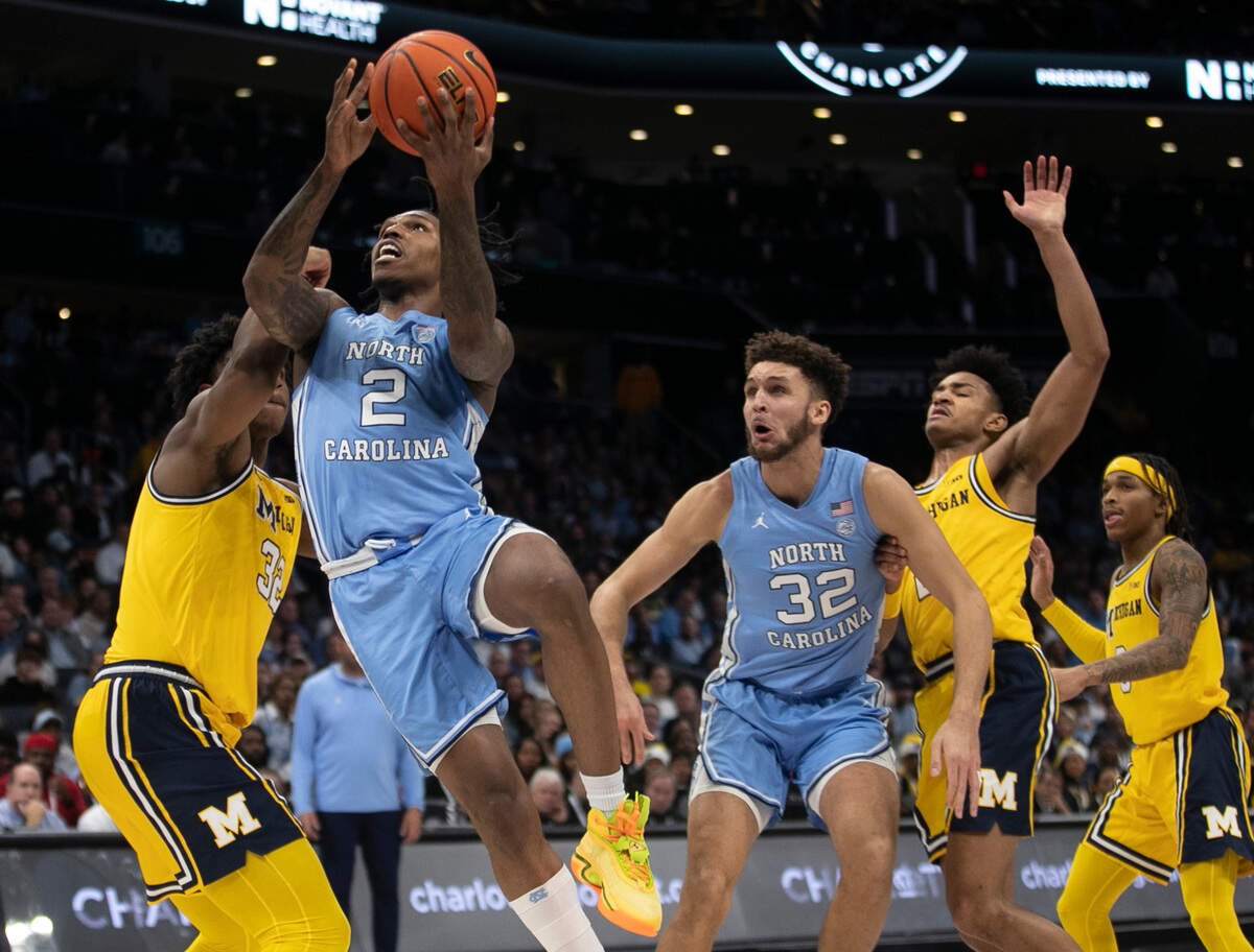 North Carolina’s Caleb Love (2) drives to the basket against Michigan’s Tarris Reed Jr. (32) in the second half on Wednesday, December 21, 2022 at the Spectrum Center in Charlotte, N.C.