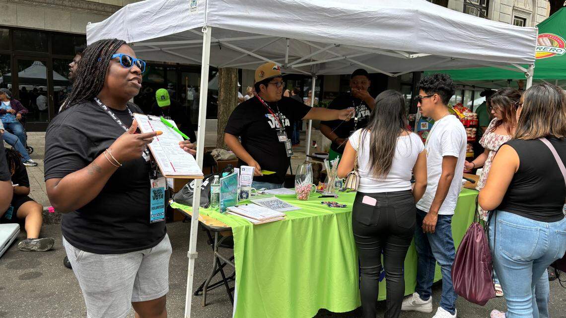 Toni Smith, left, Alex Morales and Dywuan Lockhart register voters Sunday, Sept. 15, for the “Grita. Canta. Vota” campaign at the 30th annual La Fiesta del Pueblo in downtown Raleigh.
