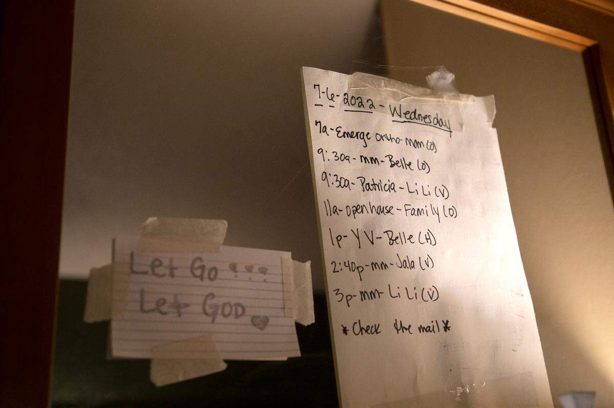 A hand-written note posted on a mirror of an extended-stay hotel room displays the day’s schedule for Wednesday, July 6, 2022, in Raleigh, N.C. LaSherron Geddie, who has lived with her family at the hotel since May, said she tries to post the following day’s schedule by 6 p.m. every evening. “Especially living in this situation, it’s so sporadic. Organization is helpful — you don’t know from one day to the next where you’ll be or what you’ll be doing.”