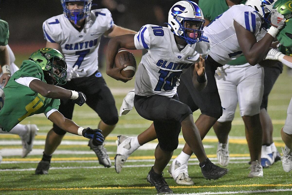 Clayton quarterback Johnathan Montague (10) rushes for yardage past Cardinal Gibbons’ Braylon Peebles (4) during the second half. The Clayton Comets and the Cardinal Gibbons Crusaders met in the third round of the NCHSAA 4A Football Playoffs in Raleigh, N.C. on November 17, 2023.