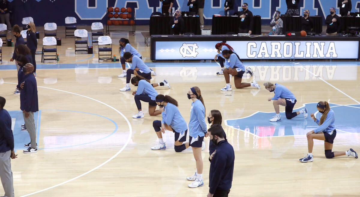 Some North Carolina players kneel during the national anthem before N.C. State’s game against UNC at Carmichael Arena in Chapel Hill, N.C., Sunday, February 7, 2021.