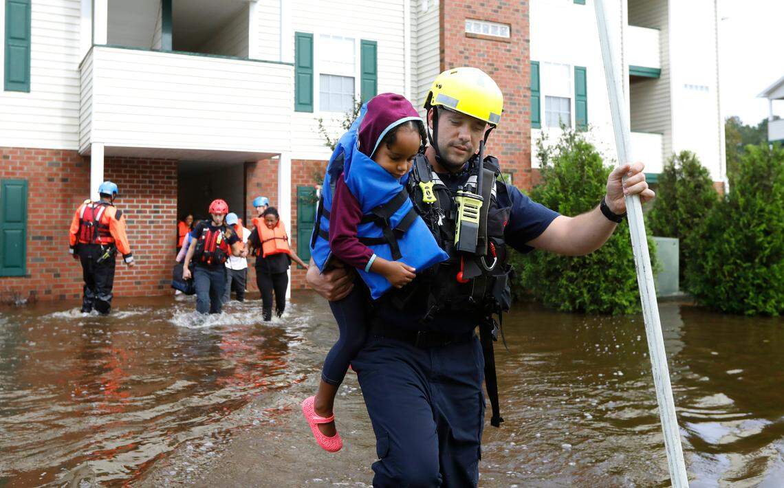Capt. Steven Barker with Spring Lake Fire Department helps evacuate residents from the Heritage at Fort Bragg Apartments in Spring Lake, N.C., Monday Sept. 17, 2018.