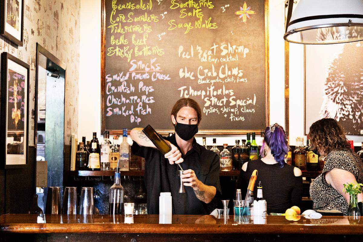 St. Roch’s bartender, Nick Baxter, center, prepares for dinner service Friday, Sept. 24, 2021, after the downtown Raleigh restaurant recently reopened.