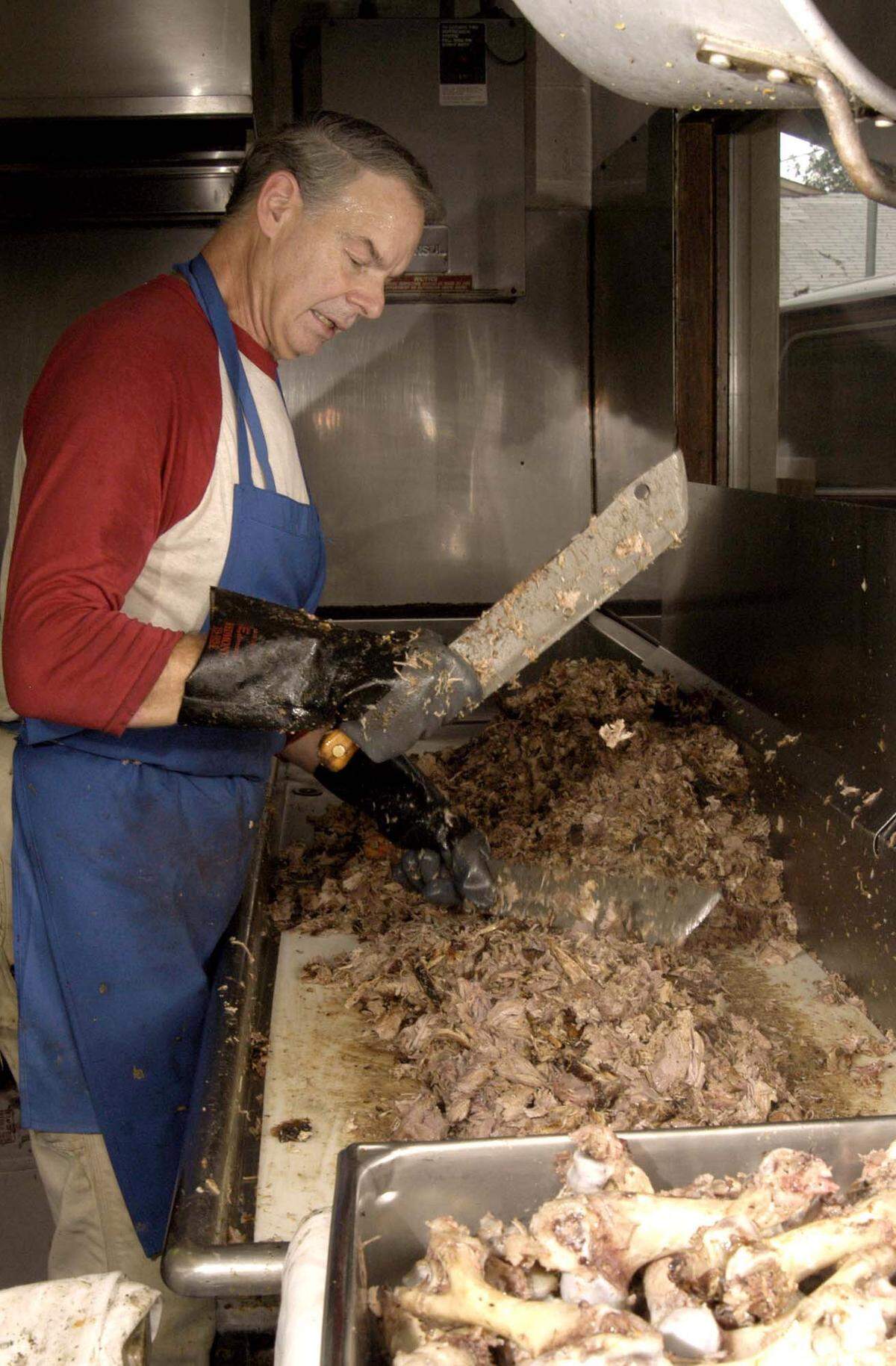 Keith Allen, of Allen and Son Barbecue, chops the meat after pulling it off the bones during a busy lunch hour, in Chapel Hill, North Carolina, on Wednesday, September 15, 2004.