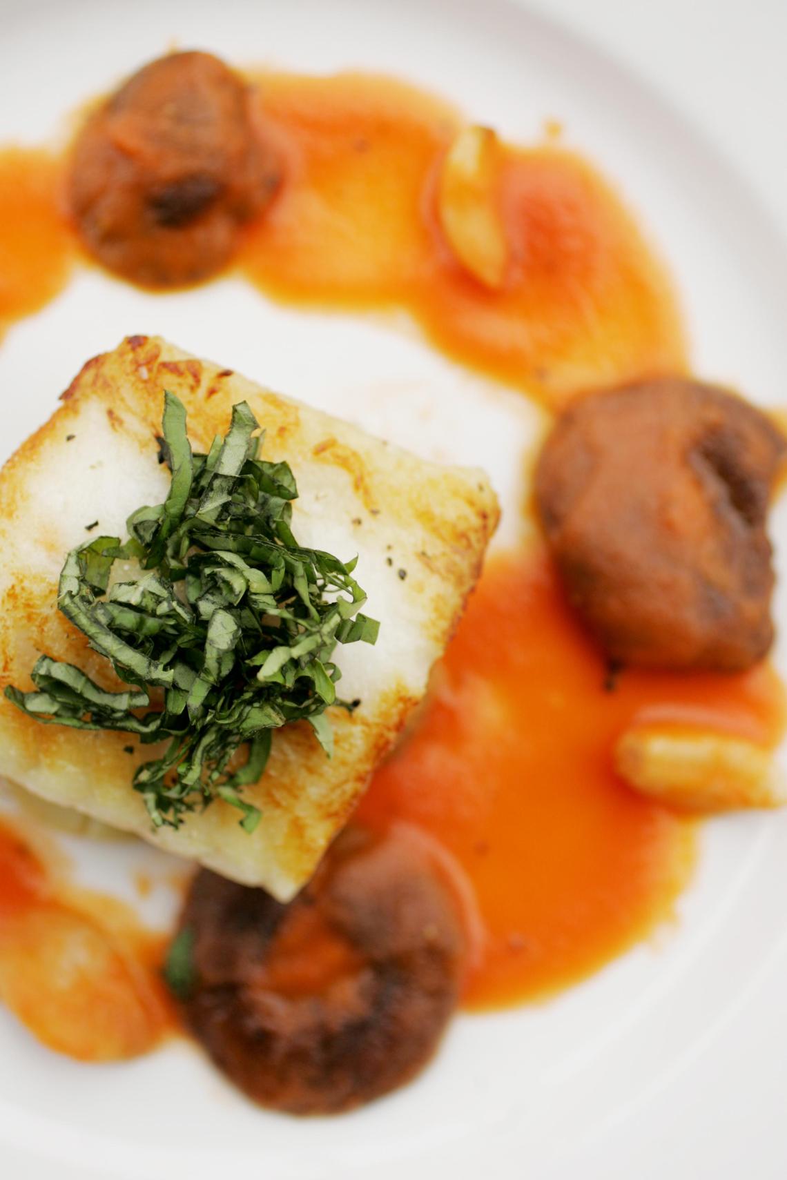 Pan-seared sea bass with shittake mushrooms, tomato broth, garlic confit and white truffle polenta is served at Sitti in downtown Raleigh.