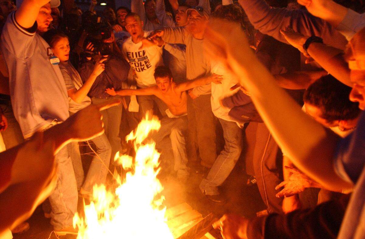 A UNC fan prepares to jump over a bonfire in the middle of Franklin St. in downtown Chapel Hill after UNC’s victory over Duke Sunday, March 6, 2005.
