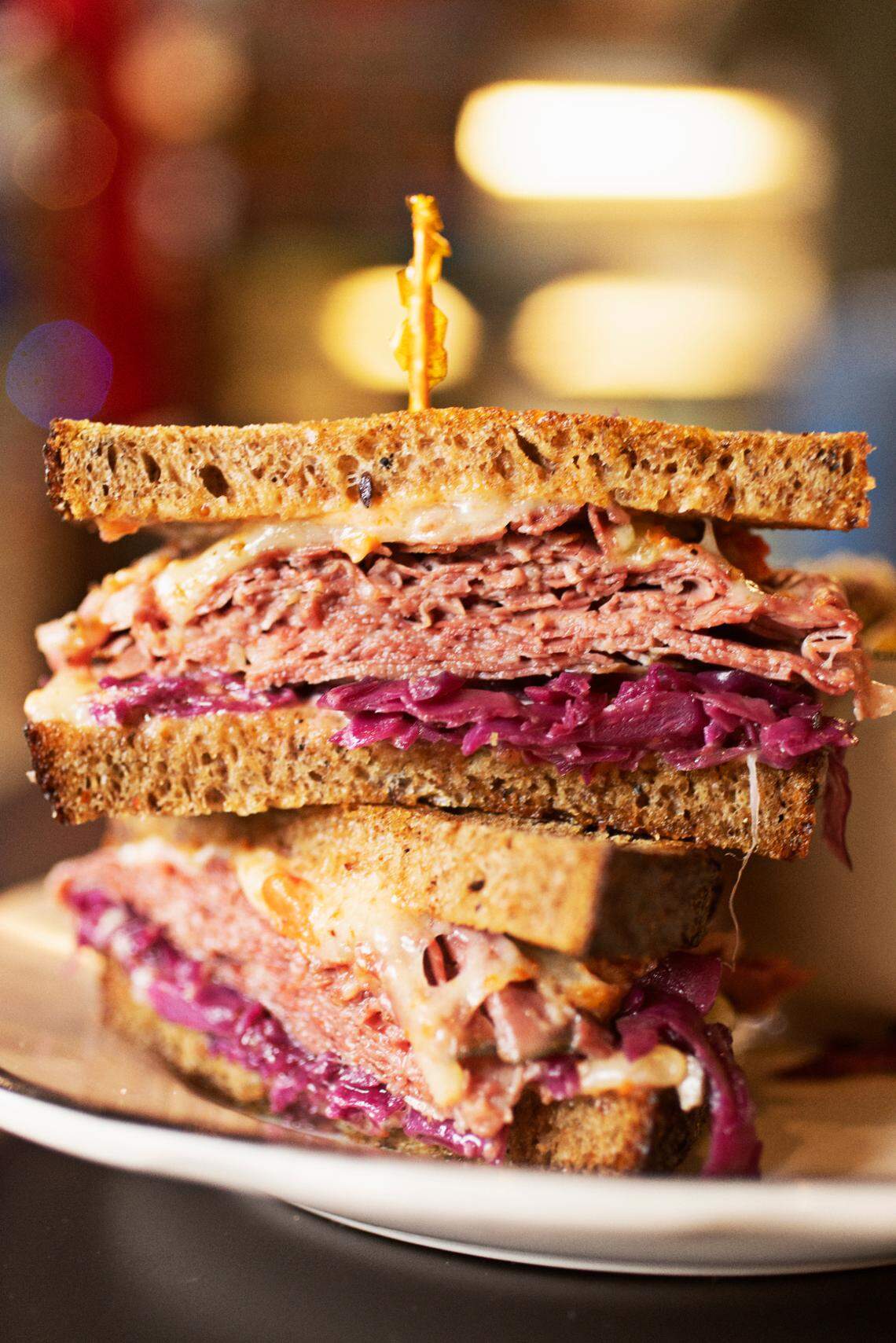 Raleigh’s (ish) delicatessen makes a housemade pastrami or corned beef sandwich with Swiss, Super Russian, braised purple cabbage, on Boulted Bread rye.