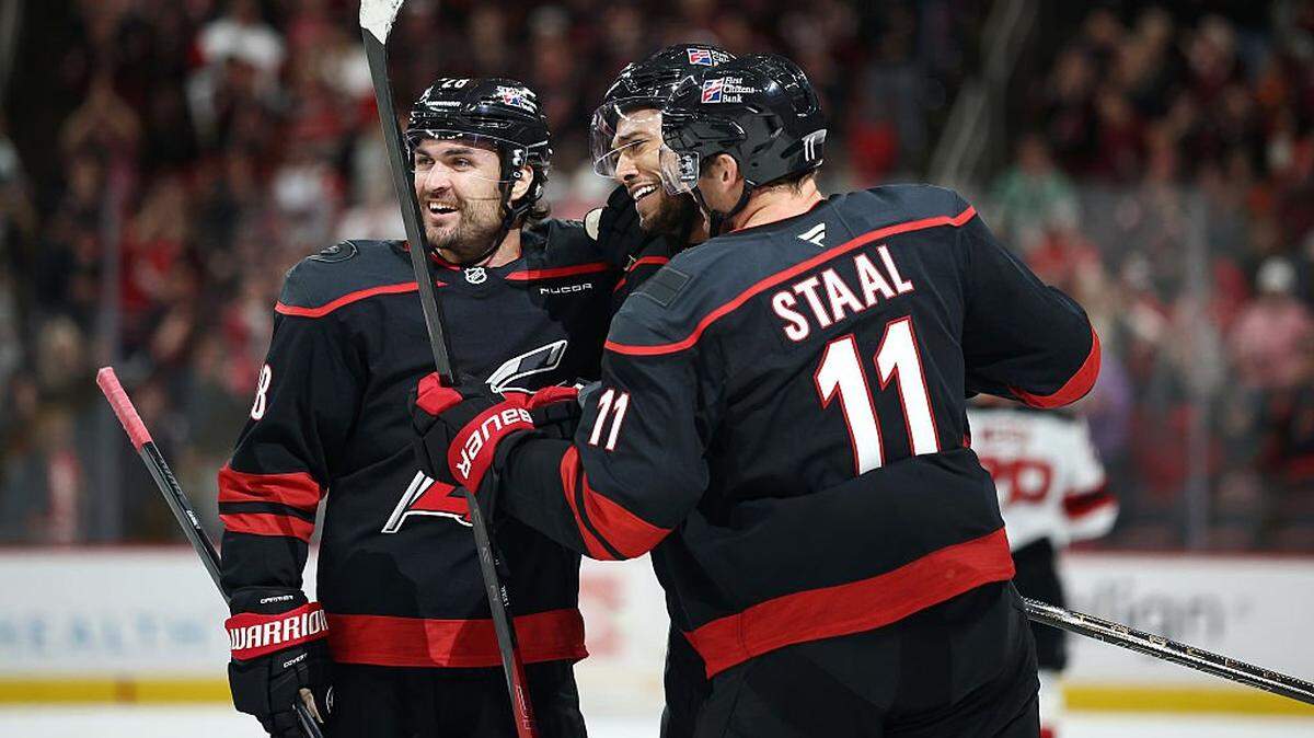 K'Andre Miller of the Carolina Hurricanes reacts with his teammates after scoring a goal during the second period of the game against the New Jersey Devils at Lenovo Center on October 09, 2025 in Raleigh, North Carolina. This is Millers first goal playing for the Carolina Hurricanes.