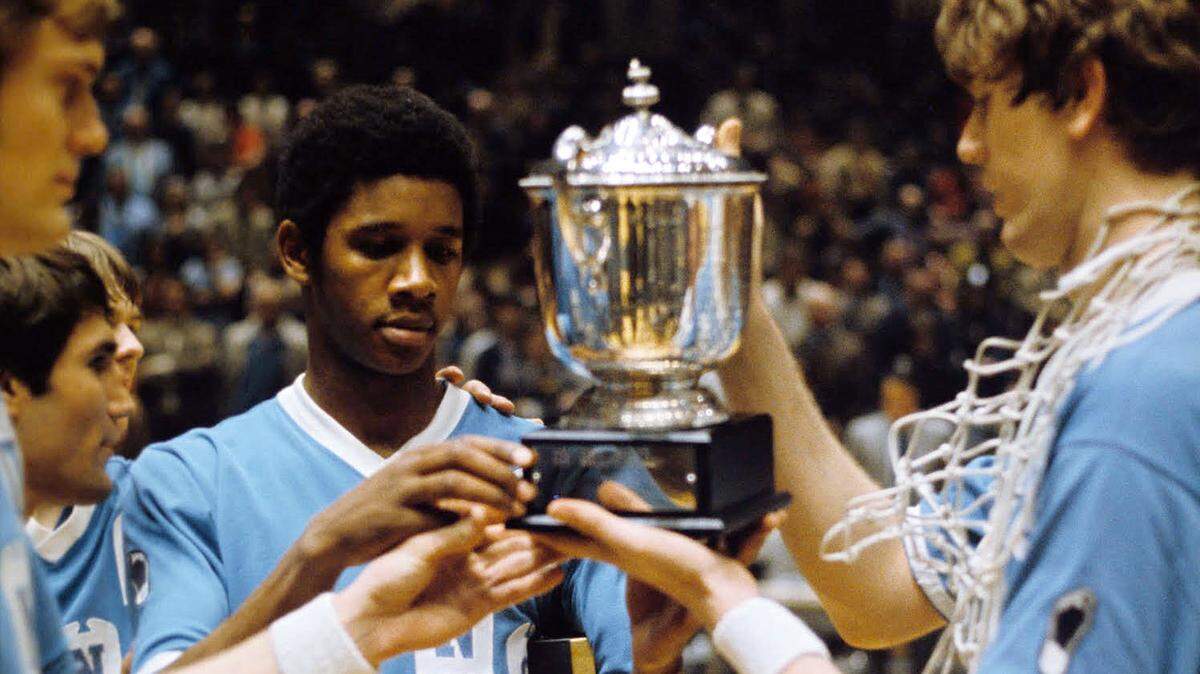 Bill Chamberlain (center) holds the 1971 NIT trophy, which UNC won after defeating Duke in an NIT semifinal.