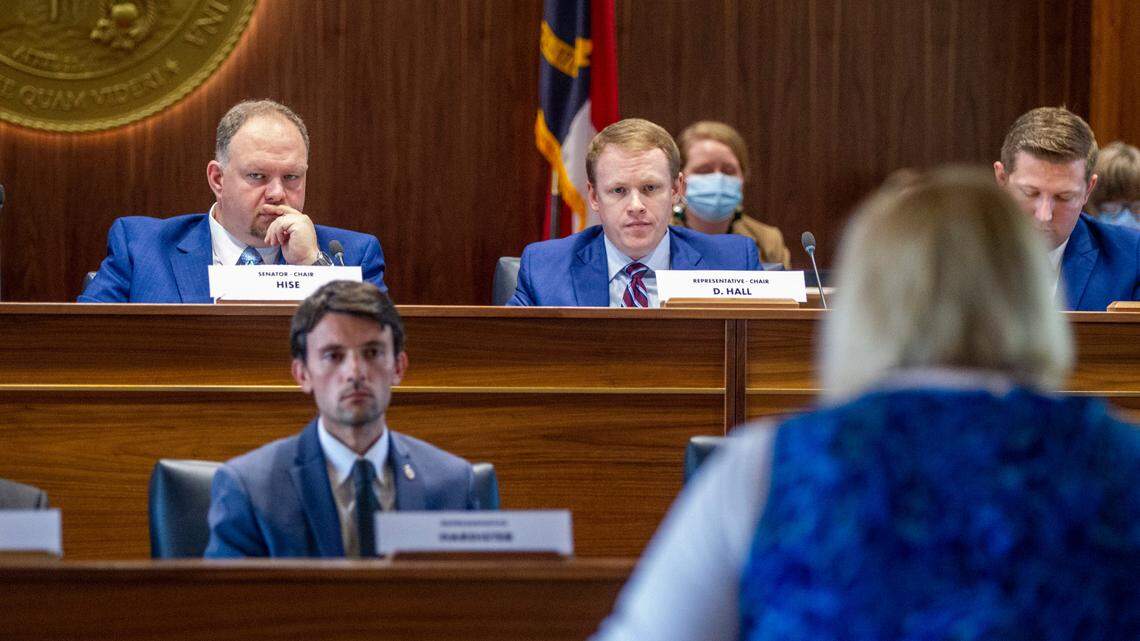 Top state redistricting legislators, Sen. Ralph Hise, top left, and Rep. Destin Hall, top right, listen as several dozen members of the public address state lawmakers during a public comment hearing on Senate and House legislative redistricting maps Monday, Oct. 15, 2021 at the Legislative Building in Raleigh.