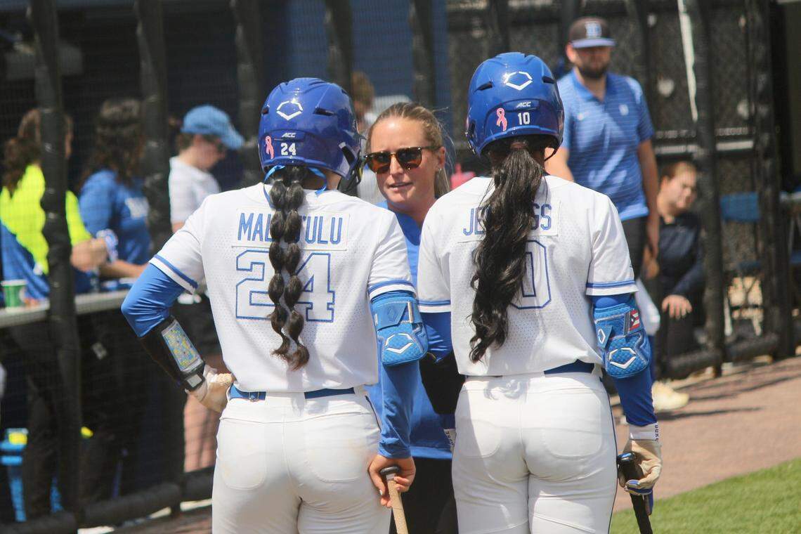 Duke outfielder D’Auna Jennings (10) and utility player Thessa Malau’ulu (24) talk with associate head coach Taylor Wike at a timeout during the Blue Devils’ 6-5 loss to Notre Dame on Saturday, April 19, 2025, at Duke Softball Stadium in Durham, N.C.
