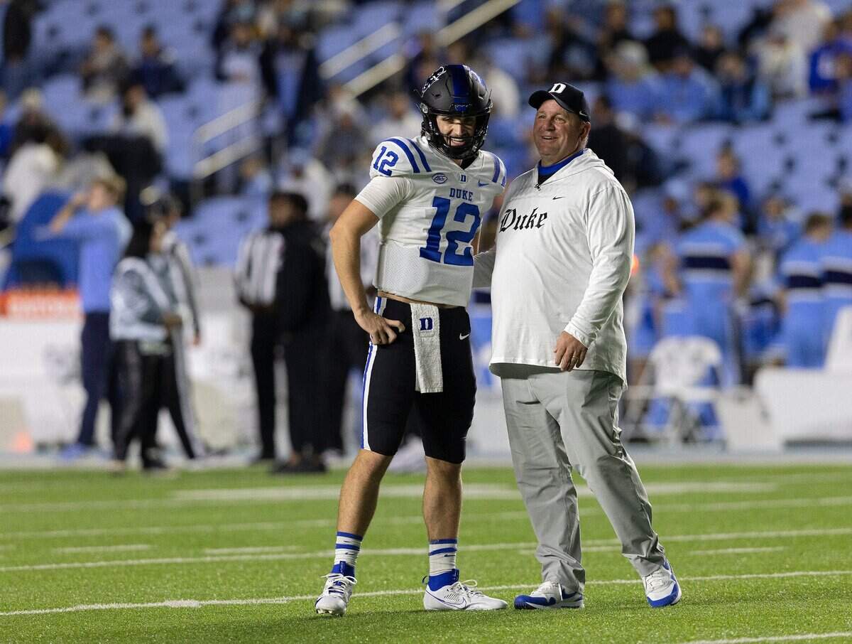 Duke head coach Mike Elko shares a word with quarterback Grayson Loftis prior to the Blue Devils’ game against North Carolina on Saturday, Nov. 11, 2023, at Kenan Stadium in Chapel Hill, N.C.