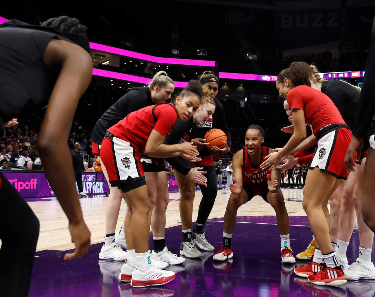 Teammates huddle around N.C. State’s Aziaha James prior to the Wolfpack’s game against top-ranked South Carolina on Sunday, Nov. 10, 2024, at Spectrum Center in Charlotte, N.C.