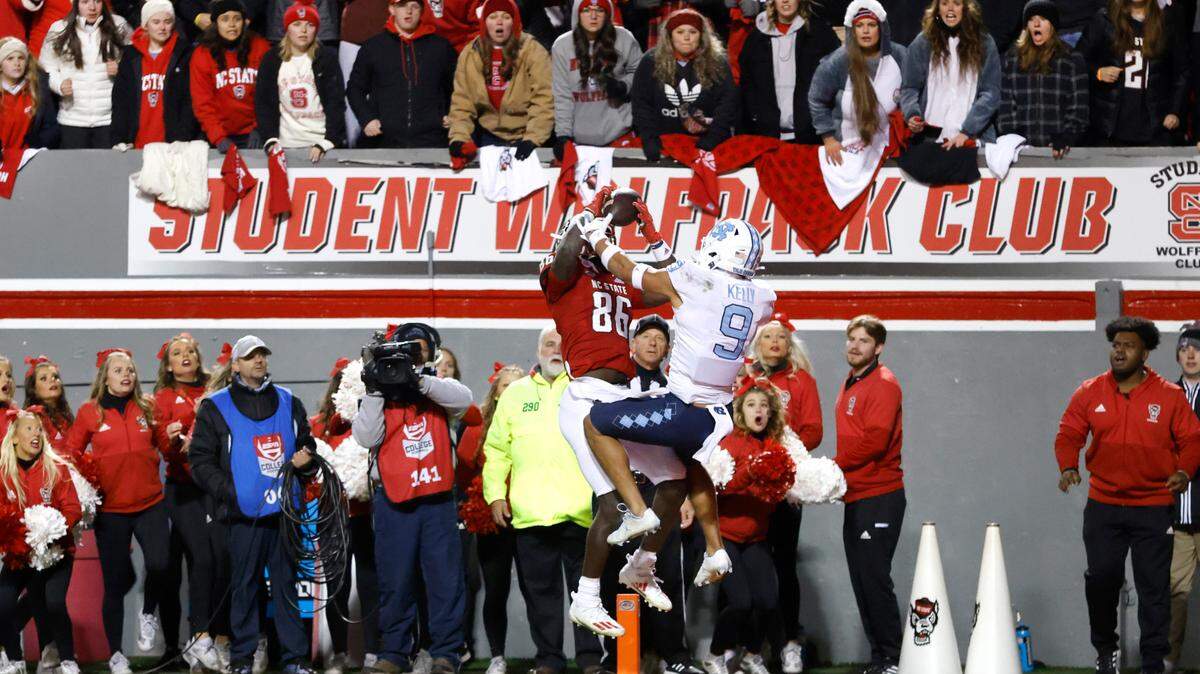 N.C. State wide receiver Emeka Emezie (86) makes what would be the game winning touchdown reception as North Carolina defensive back Cam’Ron Kelly (9) defends late in the second half of N.C. State’s 34-30 victory over UNC at Carter-Finley Stadium in Raleigh, N.C., Friday, November 26, 2021.