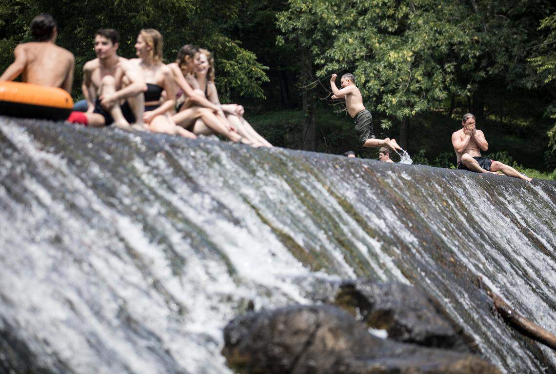 People at the Festival for the Eno enjoy swimming and cooling off in the water at West Point on the Eno on Thursday, July 4, 2019.