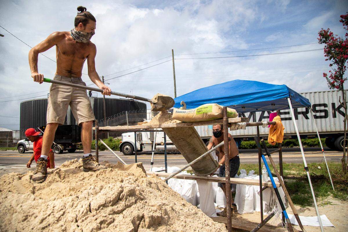 From left, Trey Bledsoe and his father Mike Bledsoe Jr., operate a makeshift sand bagging operation in Wilmington Monday, Aug. 3, 2020 in preparation for Tropical Storm Isaias. The storm is expected to strengthen to a hurricane before making landfall.