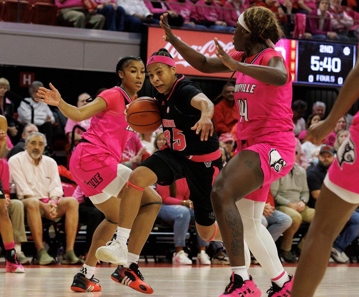 N.C. State’s Zoe Brooks drives between Louisville’s Nyla Harris and Olivia Cochran during the first half of the Wolfpack’s 77-67 win on Monday, Feb. 5, 2024, at Reynolds Coliseum in Raleigh, N.C.