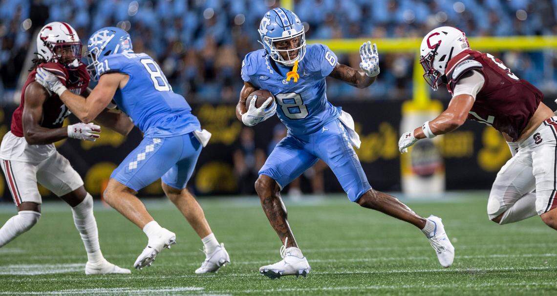 North Carolina’s Kobe Paysour (8) looks for running room against South Carolina’s Stone Blanton (52) in the second quarter on Saturday September 2, 2023 at Bank of America Stadium in Charlotte, N.C.