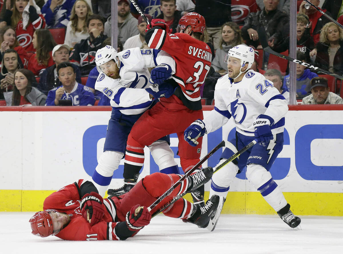 Carolina Hurricanes’ Jordan Staal (11) falls to the ice with an injury as Andrei Svechnikov (37), of Russia, struggles with Tampa Bay Lightning’s Braydon Coburn (55) and Ryan Callahan (24) during the first period of an NHL hockey game in Raleigh, N.C., Thursday, March 21, 2019. (AP Photo/Gerry Broome)