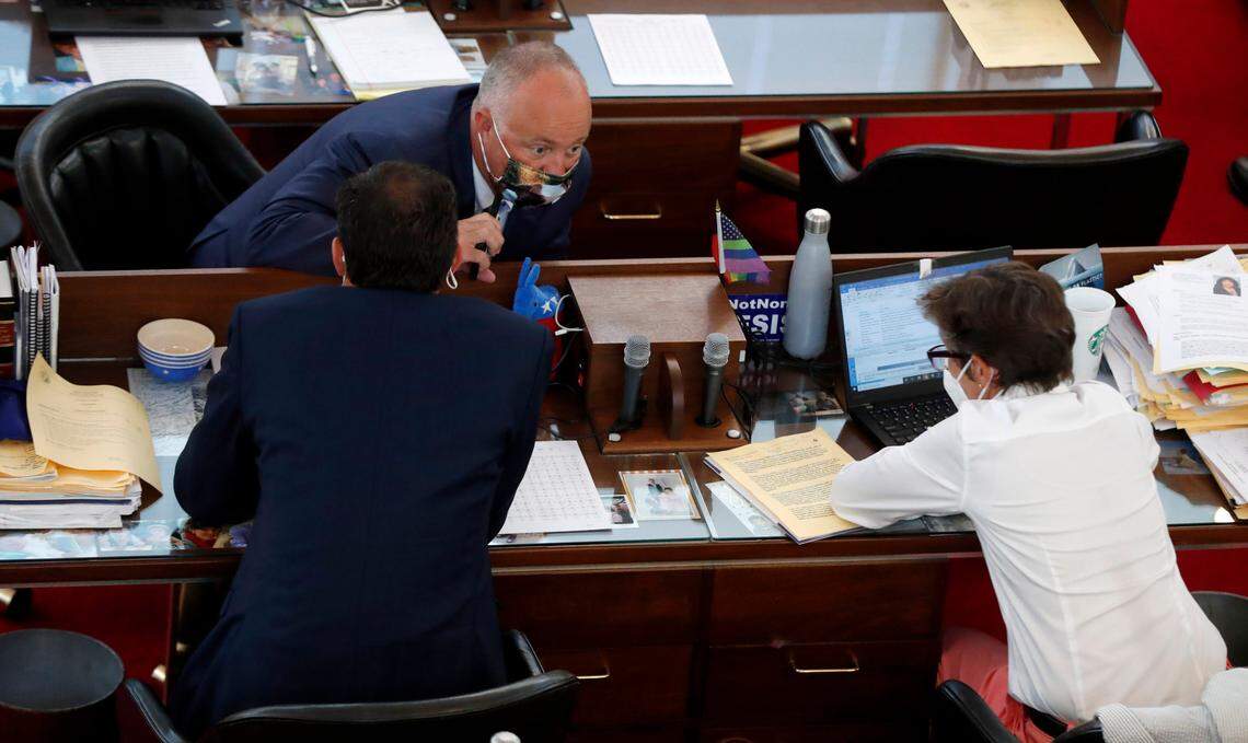 Rep. Darren Jackson, top, talks with Rep. Graig Meyer, left, and Rep. Pricey Harrison before the start of a brief session Wednesday, Sept. 2, 2020.