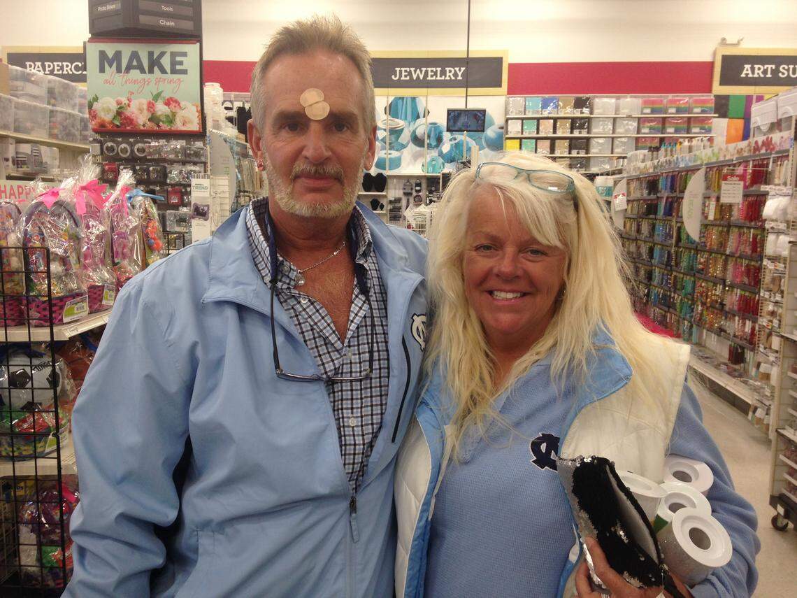 Tar Heel fans Lee Johnson, left, of Raleigh, and his girlfriend Dava House, of Garner are not really superstitious, but have plenty of  UNC-branded wearables.