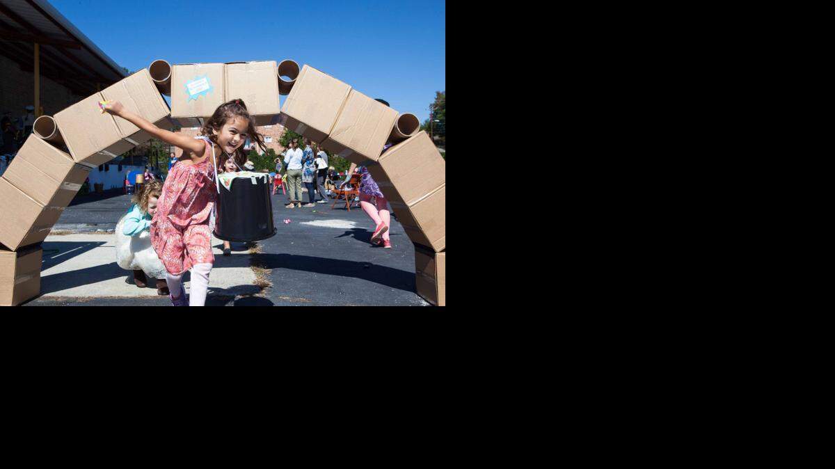 Ruby Monje Silva, 5, runs out from under a cardboard bridge during the grand opening celebration of The Scrap Exchange in Durham on Sunday Oct. 5, 2014. The Scrap Exchange is a nonprofit that collects unwanted materials from the community to redistribute for creative reuse in their new 1,200 square foot facility on Chapel Hill Road.