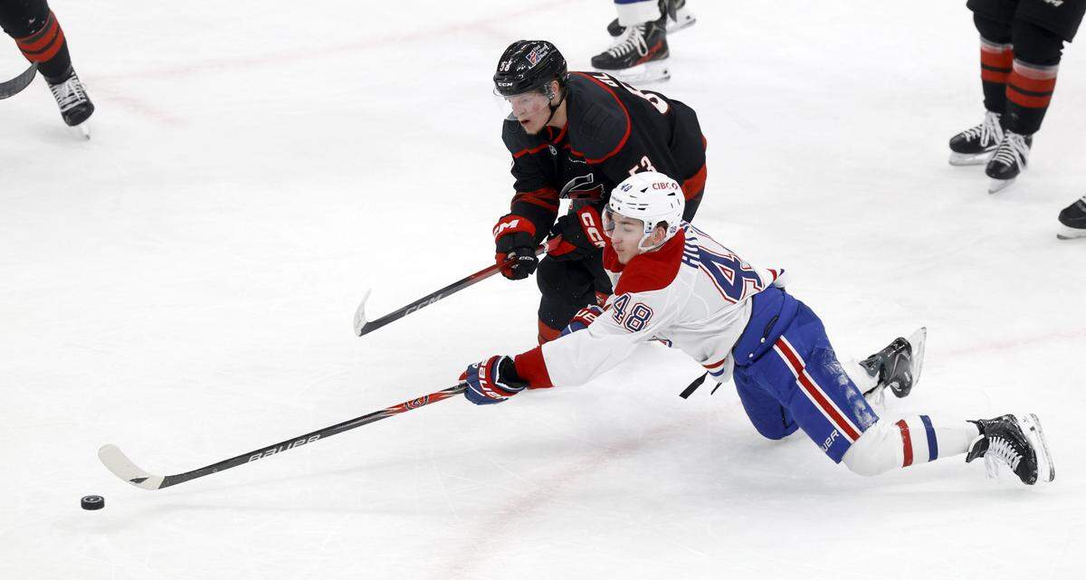 Carolina's Jackson Blake (53) and Montréal's Lane Hutson (48) go after the puck during the second period of the Hurricanes’ game against the Canadiens in game one of the Eastern Conference Finals at the Lenovo Center Thursday, May, 21, 2026.