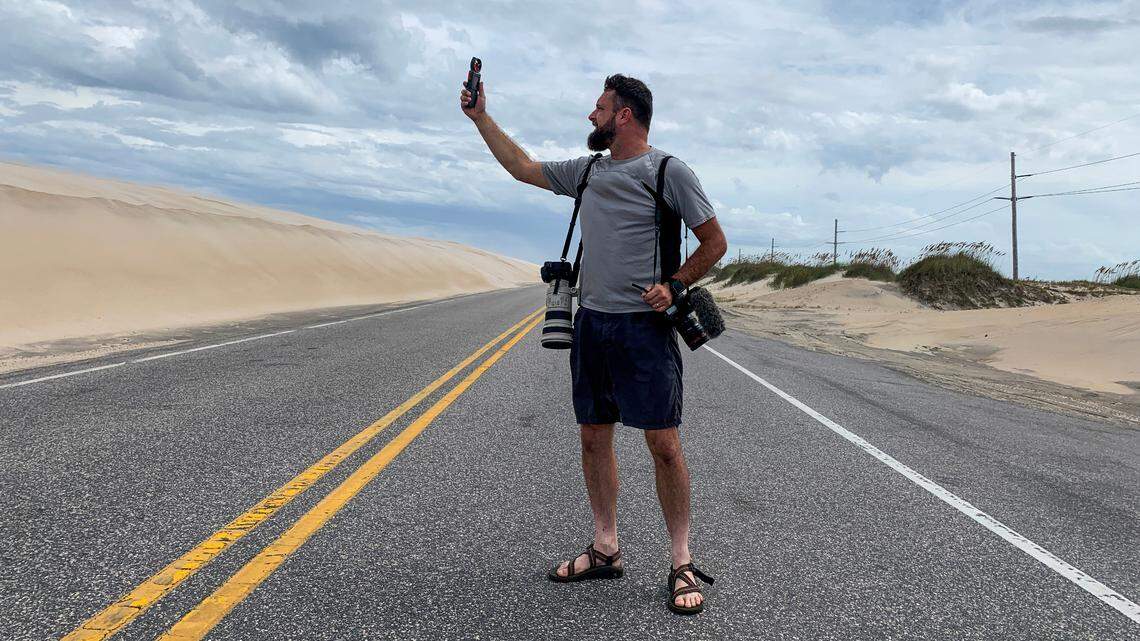 News & Observer veteran photojournalist Travis Long uses an anemometer to measure windspeed on North Carolina Highway 12 near Cape Hatteras prior Hurricane Dorian making landfall in 2019.
