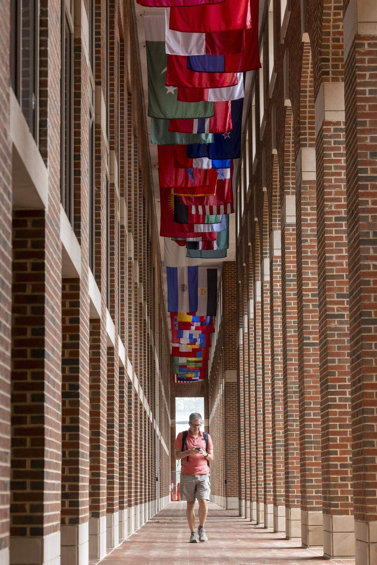 The flags representing nationalities of current UNC Kenan-Flagler students hang above the walkway at the McColl Building on Friday, August 1, 2025 in Chapel Hill, N.C.